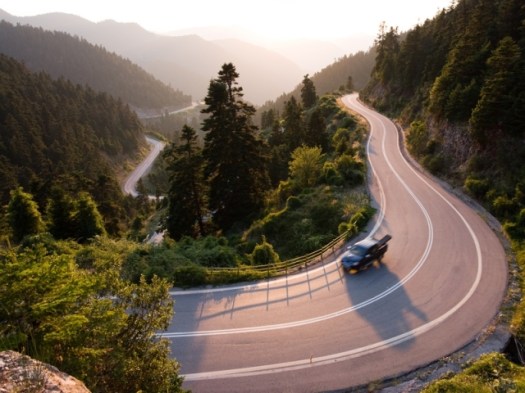 pickup crosses mountain road winding in twilight